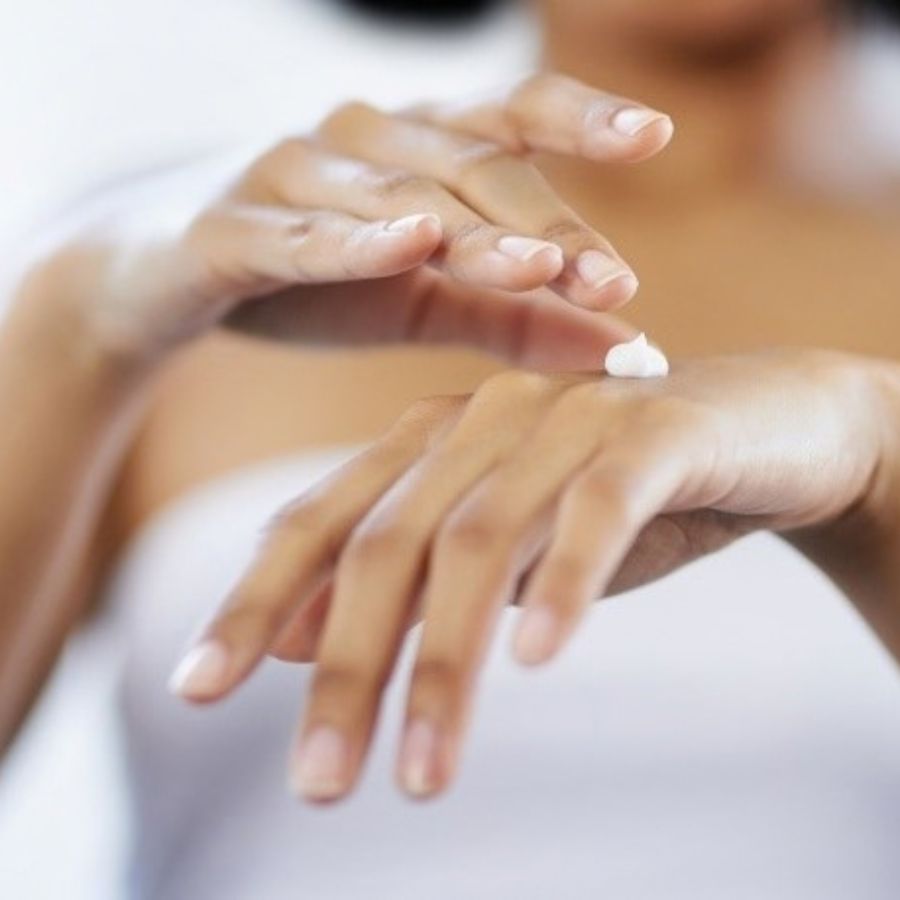 Woman applying cream to the back of her hand