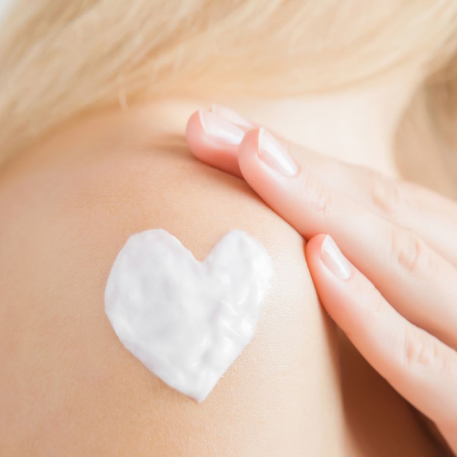 Cream in a heart shape on a woman’s shoulder.