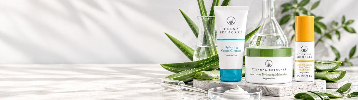 Eternal Skincare cleanser, aloe vera moisturiser and sun protection cream displayed beside fresh aloe vera leaves.