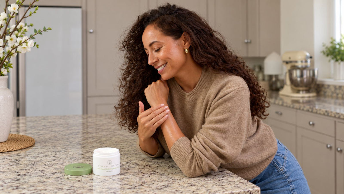 Woman applying moisturiser to her forearm with an open Eternal Skincare pot beside her.